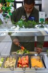 U.S. Air Force Tech. Sgt. Joey Wright of the 99th Airlift Squadron assembles a salad at Joint Base Andrews, Md., March 16, 2015, with tongs color coded according to the Go For Green program. Go For Green allows Airmen quickly make informed decisions about food choices, with the goal of supporting performance, readiness and resilience. 