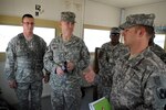 Spc. Kurstin Truhitte stands next to Maj. Gen. Randy Manner, Third Army/U.S. Army Central deputy commanding general, while Capt. Dewitt Revels explains perimeter security at Camp As Sayliyah, Qatar, June 17, 2010. Revels is the commander of Bravo Troop, 1st Squadron, 153rd Cavalry Regiment, 53rd Infantry Brigade Combat Team of the Florida National Guard. Bravo Troop abruptly left Kuwait in March to dissolve a long-held reliance on security contractors at Camp As Sayliyah.