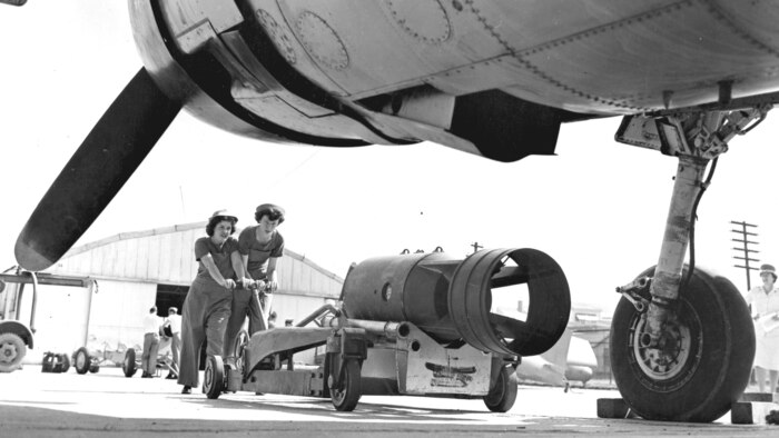 Privates Neta Irene Farrell, Rochester, N.Y., and Genevieve Evers, Woodhaven, N.Y., position a depth charge as they prepare to load and arm it in the bay of a plane during a course at the Station Ordnance School at Quantico, Va. in the early 1940s.