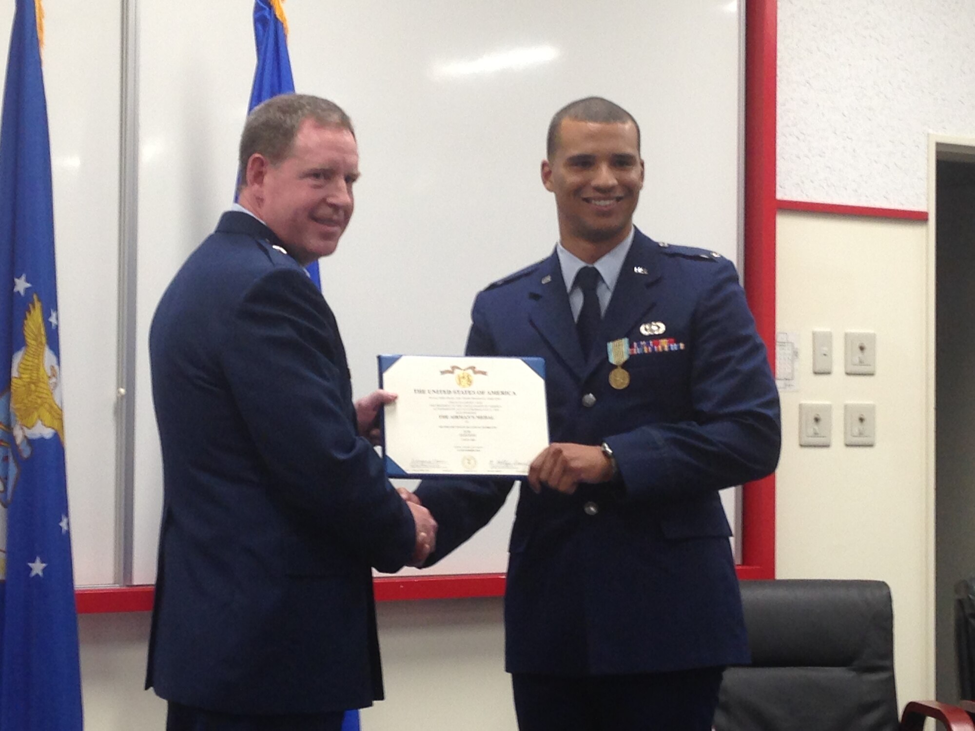 Brig. Gen. James B. Hecker presents 1st Lt. Dayton Gilbreath with a certificate to accompany his Airman’s Medal March 20, 2015, on Kadena Air Base, Japan. Gilbreath was awarded the medal for rescuing an Airman who jumped overboard from a sailing ship in the Adriatic Sea, July 3, 2012. Hecker is the commander of the 18th Wing and Gilbreath is a contracting administrator assigned to the 18th Contracting Squadron. (U.S. Air Force photo/Staff Sgt. Amber Jacobs)