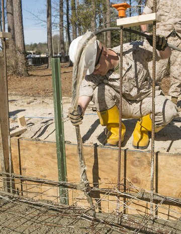 Cpl. Austin Gibson, a combat engineer with 8th Engineer Support Battalion, 2nd Marine Logistics Group and a Branson, Missouri, native, uses a concrete vibrator to remove air pockets from concrete March 18, 2015, aboard Camp Lejeune, North Carolina. Engineers with the unit are working to construct a storage facility for the unit’s martial arts equipment. Construction skills used in the project are preparing the Marines for an upcoming deployment, in which the engineers will use similar techniques to build schools and other structures during humanitarian projects. (U.S. Marine Corps photo by Cpl. Elizabeth A. Case/Released) 