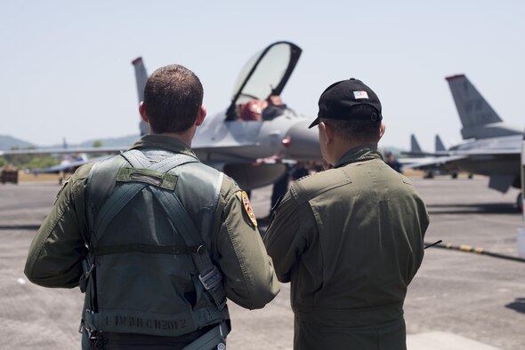 Capt. Austin Brown reviews his F-16 Fighting Falcon demonstration with a member of the Langkawi International Maritime and Aerospace Exhibition crew March 16, 2015, in Langkawi, Malaysia. Brown is a pilot assigned to the Pacific Air Forces demonstration team. Defense Department participation in the LIMA 15 airshow strengthens military-to-military relationships and underscores the cooperation agreements between the U.S. and Malaysia. (U.S. Air Force photo/1st Lt. Elias Zani)