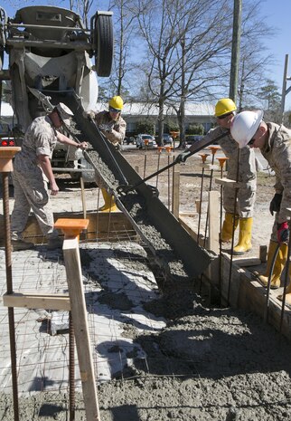 Combat engineers with 8th Engineer Support Battalion, 2nd Marine Logistics Group, use tools to pour concrete into a foundation, March 18, 2015, aboard Camp Lejeune, North Carolina. Upon completion, this building will be a storage facility for the unit’s martial arts equipment. “We’re getting ready to deploy, and the way we’re doing this project mirrors the way that we’re going to be building the schools there,” said Sgt. Christopher Panko, a combat engineer with the unit. “It’s giving the Marines good training on the process of what it takes to build from the ground up. As engineers, we normally focus on demolition. The past few years we haven’t done a lot of construction projects, and the Marines haven’t had a chance to do humanitarian work. This is a good opportunity, and with their experience level they’re doing very well.”  (U.S. Marine Corps photo by Cpl. Elizabeth A. Case/Released) 