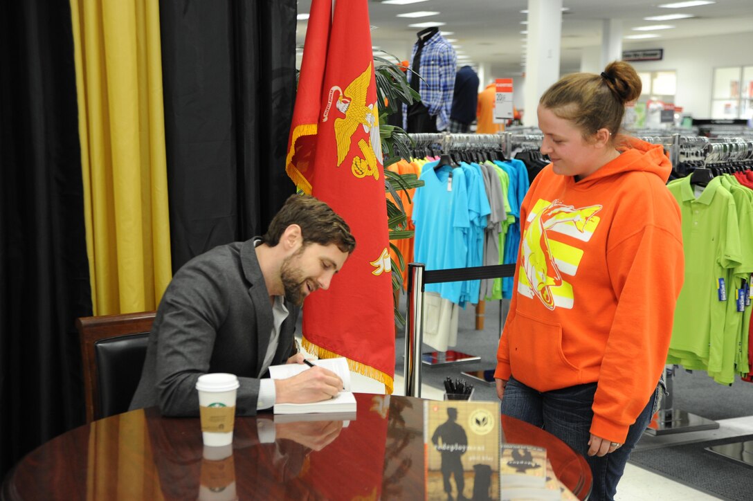 Marine veteran and author Phil Klay autographs his book Redeployment for Laikin Wilkinson at the Main Exchange on March 11. Redeployment won the 2014 National Book Award in the fiction category.