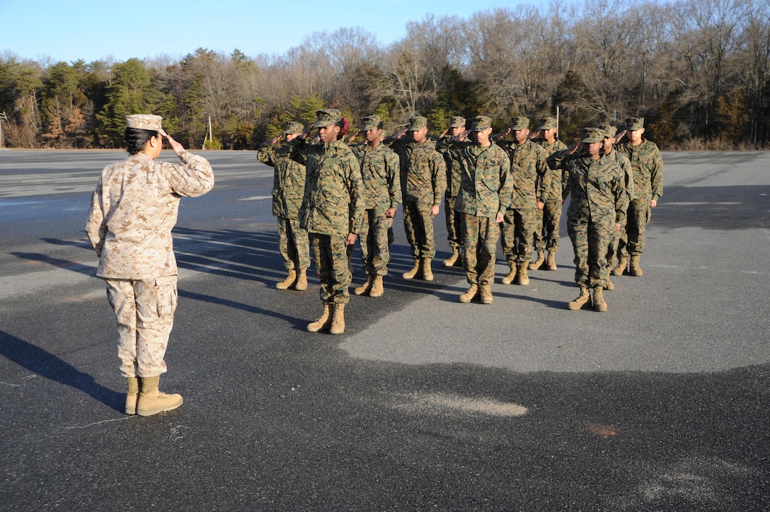 Cadet Captain Deborah Okun, 18, of Milford Mill Academy, presents the unarmed drill platoon to retired Gunnery Sgt. Samyra Rogers, left, the director of the school’s Marine Corps Junior ROTC unit. The unit visited Marine Corps Base Quantico March 12 to participate in training and get a taste of Marine Corps life.