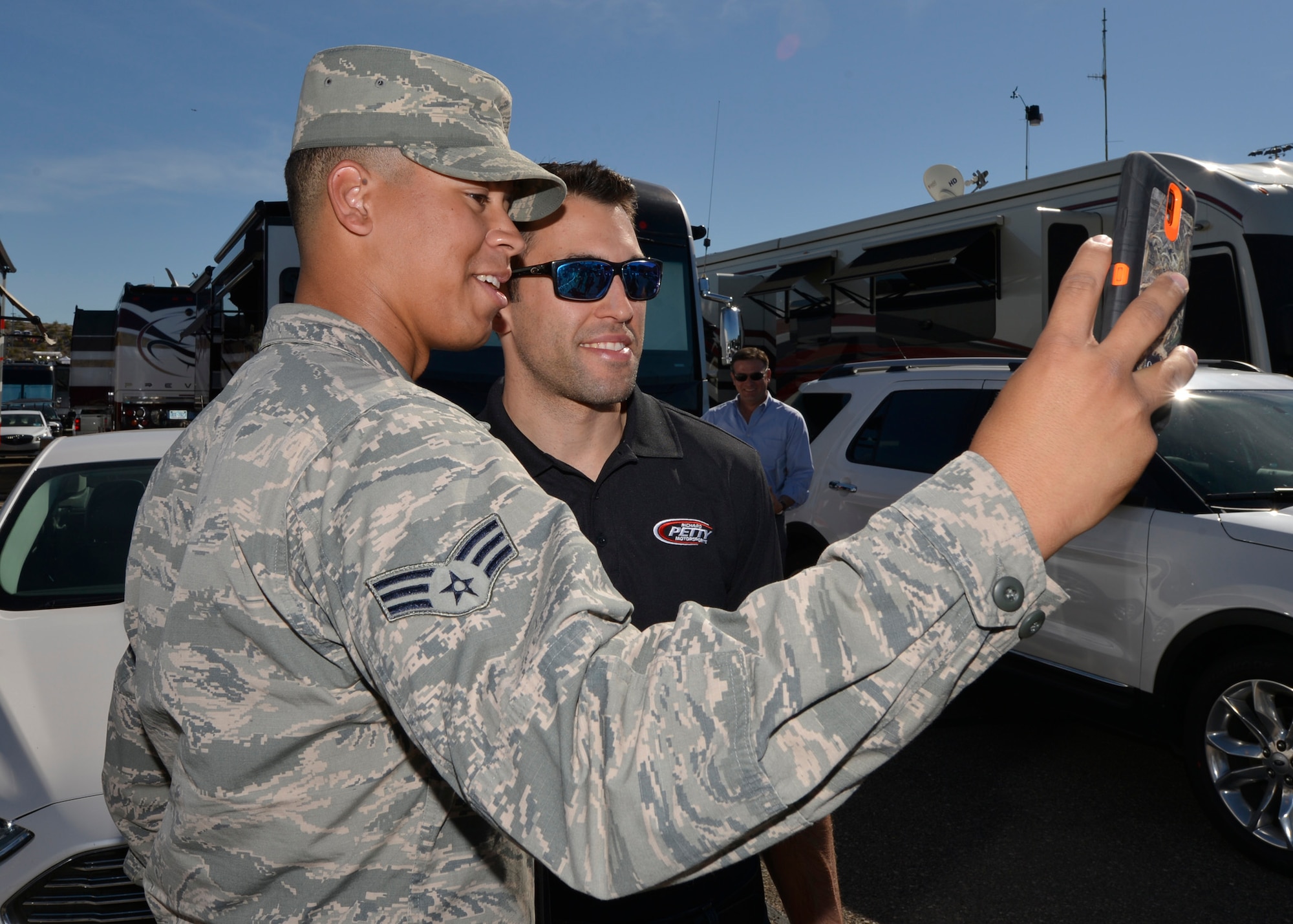 Senior Airman Tyler Carson, 56th Aircraft Maintenance Squadron maintenance technician, takes a selfie with Aric Almirola, NASCAR driver, at the Phoenix International Speedway, Arizona, March 15, 2015. Almirola talked with the Airmen and signed autographs. (U.S. Air Force photo by Senior Airman Devante Williams)