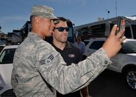 Senior Airman Tyler Carson, 56th Aircraft Maintenance Squadron maintenance technician, takes a selfie with Aric Almirola, NASCAR driver, at the Phoenix International Speedway, Arizona, March 15, 2015. Almirola talked with the Airmen and signed autographs. (U.S. Air Force photo by Senior Airman Devante Williams)
