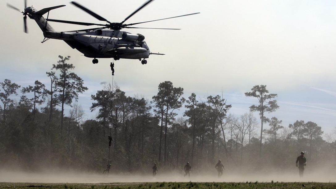 Royal Dutch Marines with the Royal Netherlands Marine Corps run back to a position after fast-roping from a CH-53 E Super Stallion at the Expeditionary Operations Training Group compound at Stone Bay aboard Marine Corps Base Camp Lejeune, North Carolina, March 17, 2015.  The helicopter hovered 50 feet above the ground with a rope hanging from a hole in the belly of the aircraft, which Royal Marines used to quickly escape and slide down the rope to safely reach the ground. 
