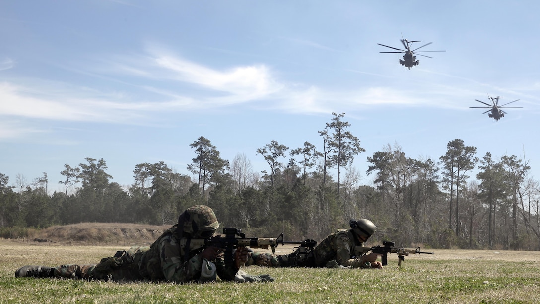 A Royal Dutch Marine with the Royal Netherlands Marine Corps secures a rope attached to a CH-53 E Super Stallion as the helicopter lands at the Expeditionary Operations Training Group compound at Stone Bay aboard Marine Corps Base Camp Lejeune, North Carolina, March 17, 2015. The helicopter hovered 50 feet above the ground with a rope hanging from a hole in the belly of the aircraft, which Royal Marines used to quickly escape and slide down the rope to safely reach the ground. 