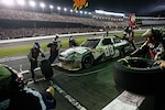 The pit crew of the No. 88 "8 Soldiers, 8 Missions" Chevrolet work quickly under the lights of the Daytona International Speedway to get Dale Earnhardt, Jr. and the No. 88 car back into the race July 3, 2010.