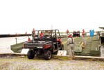 Louisiana National Guardsmen from the 2225th Multi Role Bridge Company of the 205th Engineer Brigade, load all-terrain vehicles onto a five-panel improved ribbon bridge raft in Grand Isle, La., July 2, 2010. The 2225th has been assisting civilian contractors with transporting personnel and equipment to the Grand Terre Islands off the coast of Louisiana in support of oil spill operations.