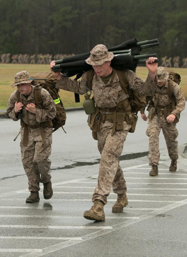 Lance Cpl. Jacob Foster, center, a rifleman with 2nd Battalion, 2nd Marine Regiment, carries a stretcher during a hike aboard Camp Lejeune, North Carolina, March 20, 2015. The unit conducted the nine-mile march in preparation for an upcoming rotation to Okinawa, Japan, as part of the unit deployment program. (U.S. Marine Corps photo by Cpl. Elizabeth A. Case/Released)