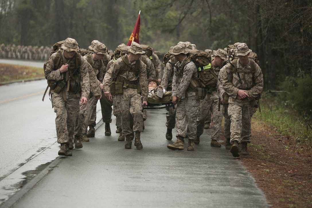 Marines with 2nd Battalion, 2nd Marine Regiment, carry their peer on a stretcher during a hike aboard Camp Lejeune, North Carolina, March 20, 2015. The unit conducted the nine-mile march in preparation for an upcoming rotation to Okinawa, Japan, as part of the unit deployment program. (U.S. Marine Corps photo by Cpl. Elizabeth A. Case/Released)