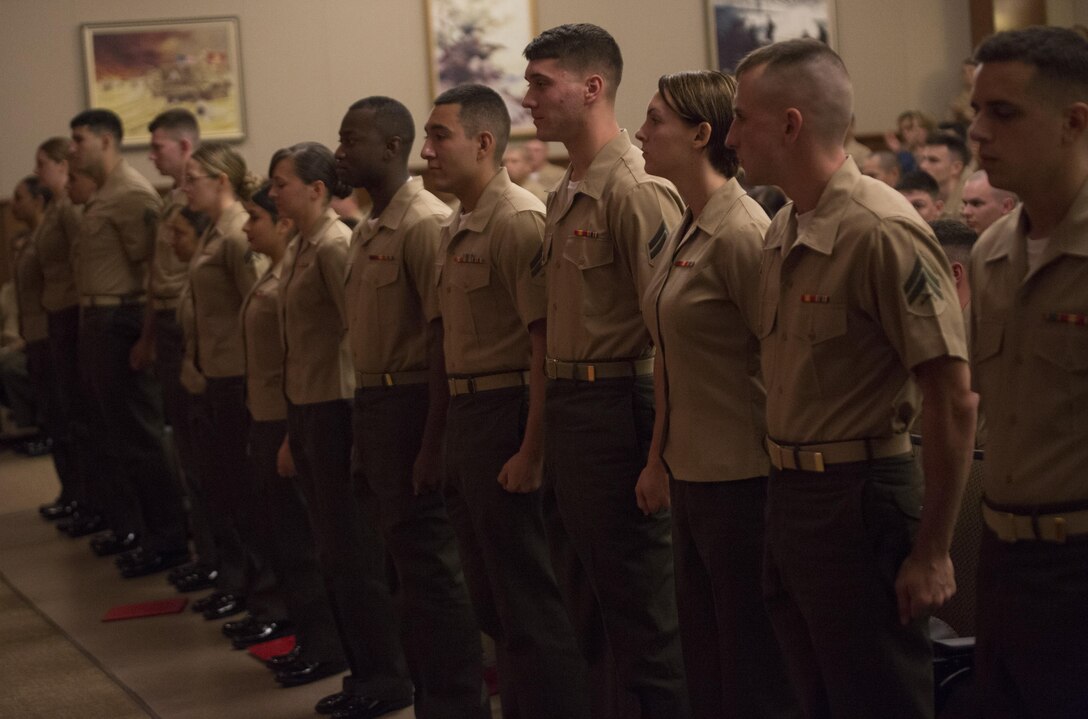 Corporals with Marine Forces Reserve stand for a round of applause at the end of the Corporal’s Course graduation at Marine Corps Support Facility New Orleans, March 20, 2015. The Marines completed more than three weeks of classroom instruction and hands on training to improve their Marine Corps knowledge and leadership abilities. (U.S. Marine Corps photo by Gabrielle Quire)