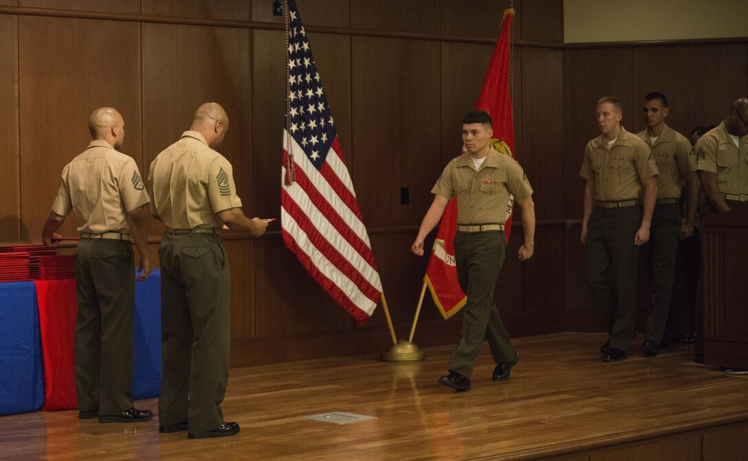 Lance corporals with Marine Forces Reserve line up to receive their diplomas for graduating the Lance Corporal Leadership and Ethics Seminar at Marine Corps Support Facility New Orleans, March 20, 2015. The seminar is a newly implemented professional military education course that will be required for a Marine to be promoted to the rank of corporal beginning Oct. 1, 2015.  (U.S. Marine Corps photo by Gabrielle Quire)
