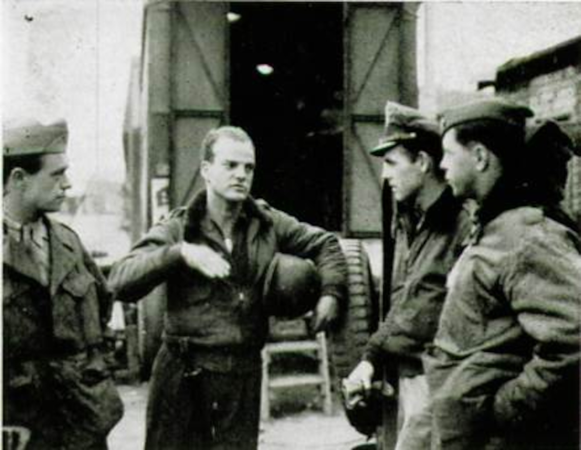 First Lieutenant Edward R. Kirkland, from Coral Gables, Florida, gesturing with hand to unidentified personnel, flew in the 406th Fighter Squadron and had an exciting story to tell after returning to the unit following his shoot down, capture and escape.  As seen here, for pilots some things are better explained by hands.  (The Story of the 371st Fighter Group in the E.T.O.)

