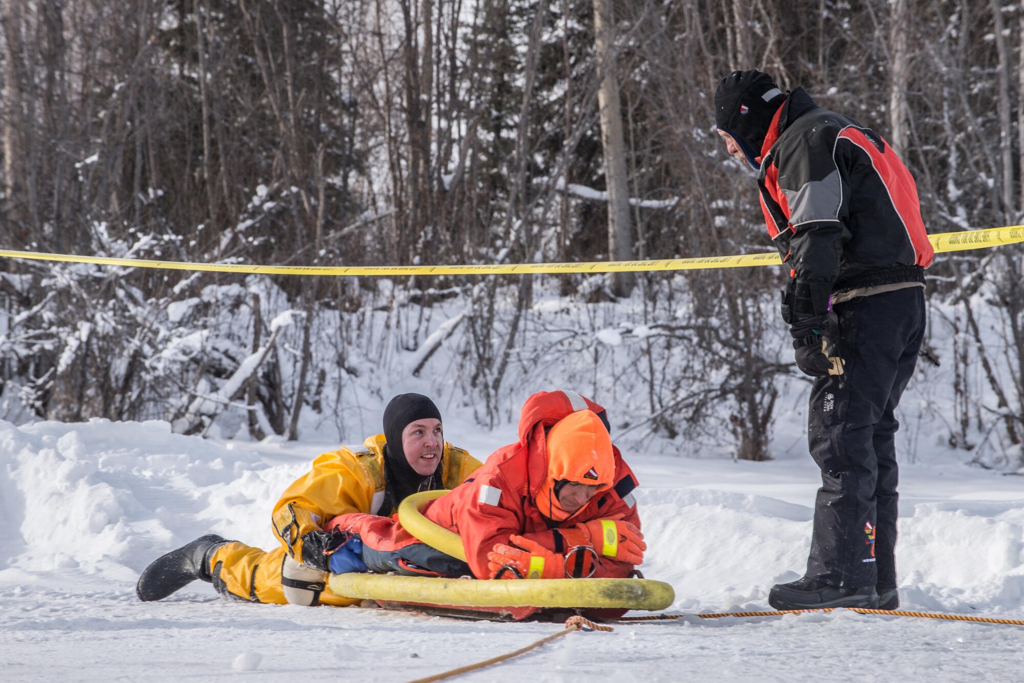 U.S. Air Force Tech. Sgt. Eric Peperissa, a 354th Civil Engineer Squadron firefighter, receives advice from Butch Hendrick, an ice rescue instructor, during training on Eielson Air Force Base, Alaska, March 12, 2015. Fire protection Airmen from the 354th CES train annually to practice rescuing a victim trapped in a broken part of a frozen lake. (U.S. Air Force photo by Staff Sgt. Joshua Turner/Released)