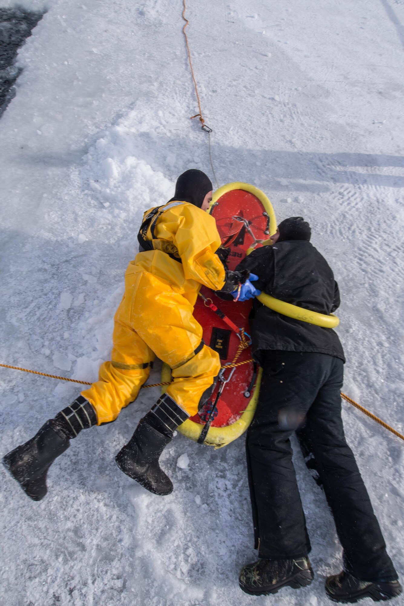 U.S. Air Force Aiman 1st Class Israel Hernandez, a 354th Civil Engineer Squadron firefighter, prepares to rescue a simulated victim during training on Eielson Air Force Base, Alaska, March 12, 2015. Fire protection Airmen from the 354th CES train annually to practice rescuing a victim trapped in a broken part of a frozen lake. (U.S. Air Force photo by Staff Sgt. Joshua Turner/Released)