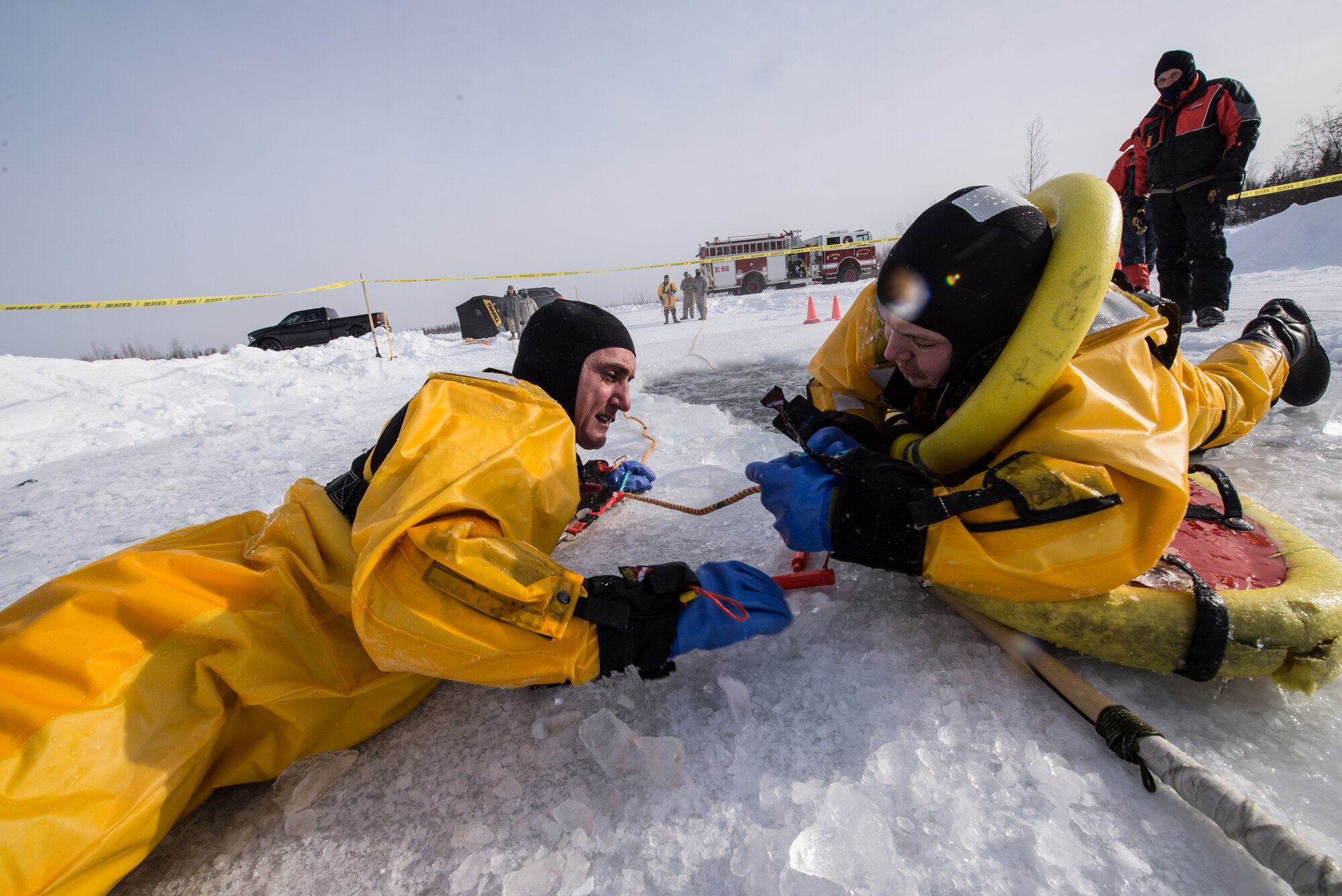 U.S. Air Force Tech. Sgt. Eric Peperissa, a 354th Civil Engineer Squadron firefighter, connects Tech. Sgt. Darnell Strausheim, also a 354th CES firefighter, to a rope during cold water training on Eielson Air Force Base, Alaska, March 12, 2015. Fire protection Airmen from the 354th CES train annually to practice rescuing a victim trapped in a broken part of a frozen lake. (U.S. Air Force photo by Staff Sgt. Joshua Turner/Released)