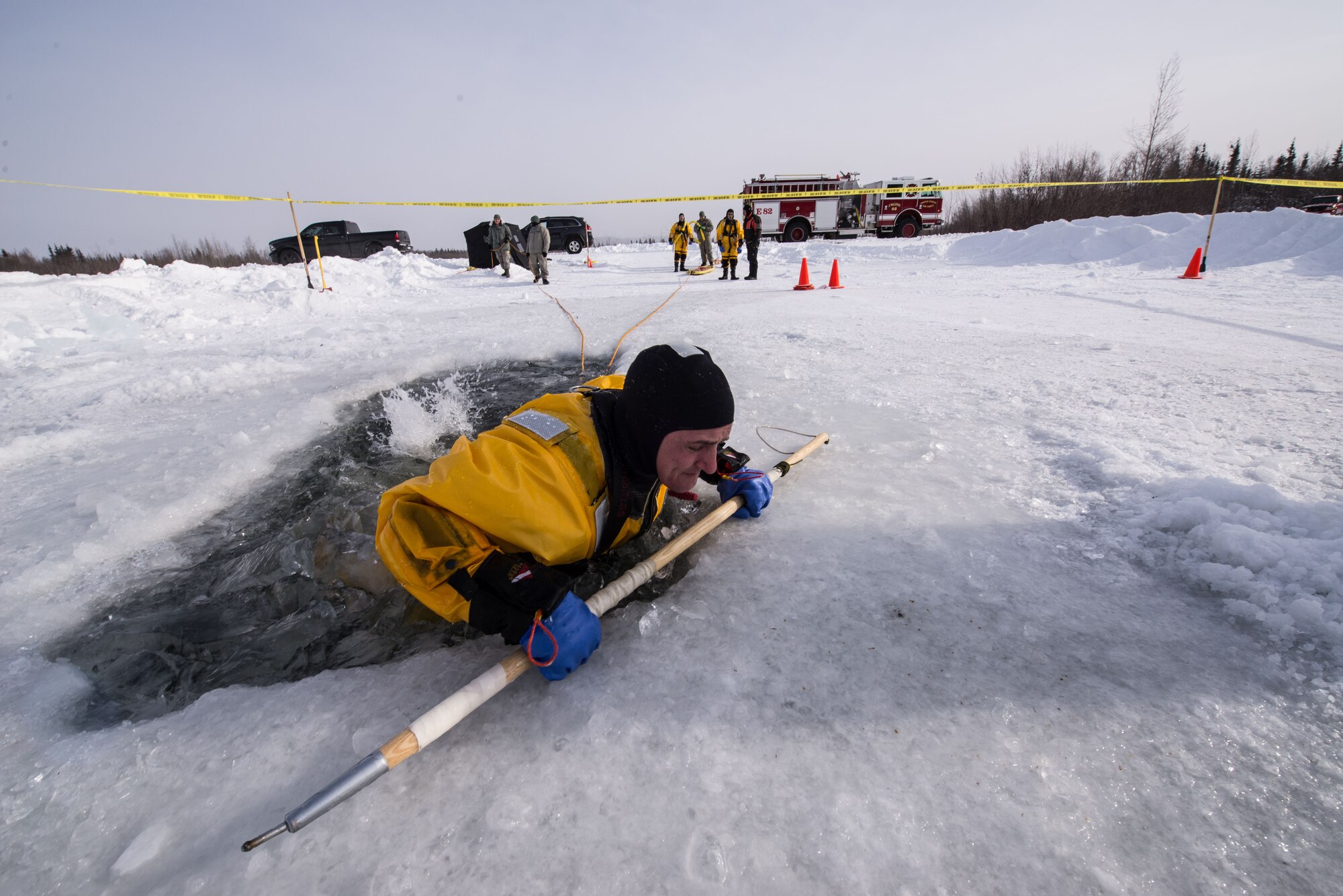 U.S. Air Force Tech. Sgt. Darnell Strausheim, a 354th Civil Engineer Squadron firefighter, attempts to pull himself out of freezing water during cold water training on Eielson Air Force Base, Alaska, March 12, 2015. Fire protection Airmen from the 354th CES train annually to practice rescuing a victim trapped in a broken part of a frozen lake. (U.S. Air Force photo by Staff Sgt. Joshua Turner/Released)