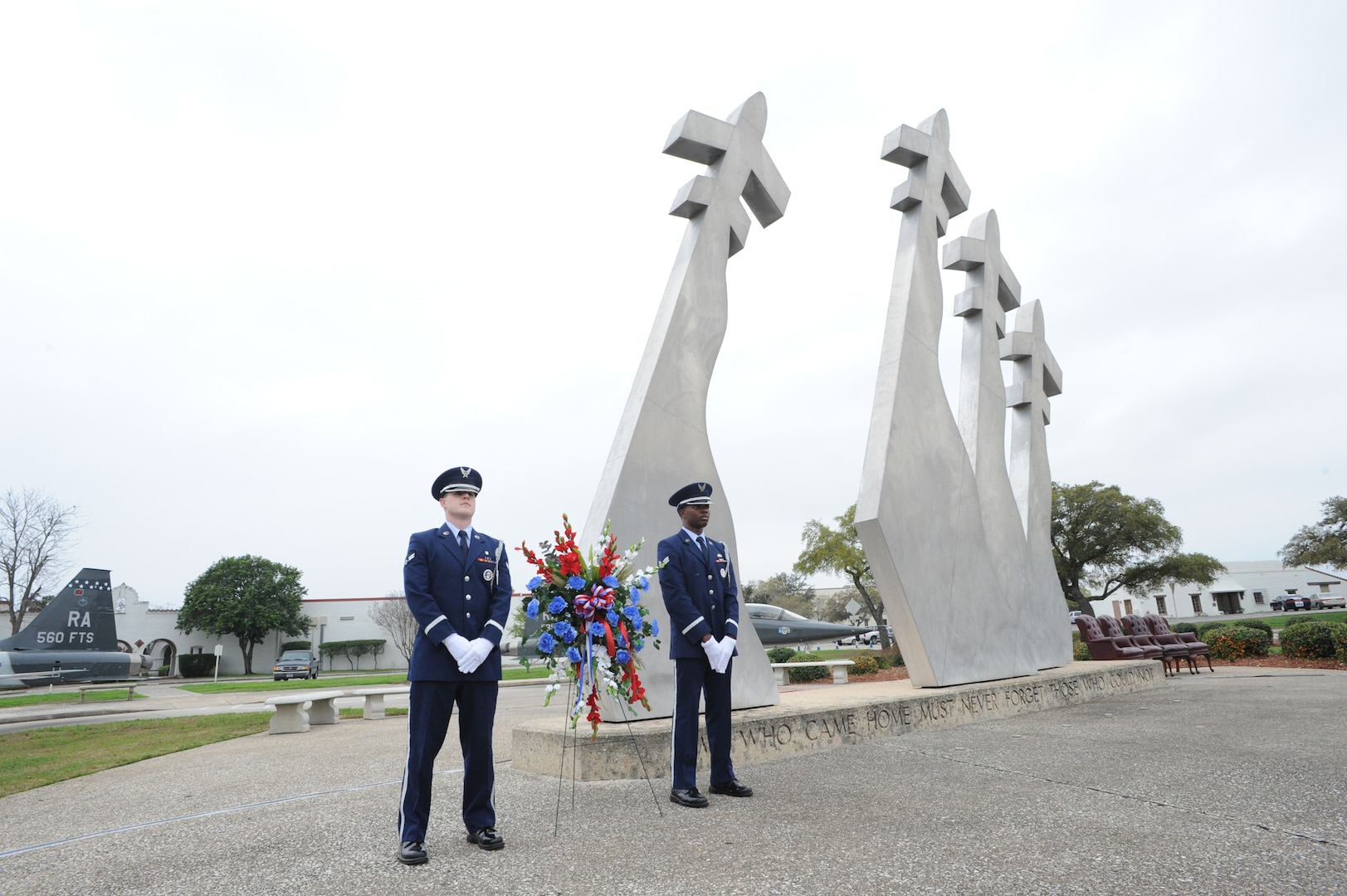 Airman 1st Class Hayden Tondee (left) and Senior Airman Willie Muhammad (right), Joint Base San Antonio Honor Guard members, stand at the Missing Man Memorial before the  wreath laying ceremony, which was held in conjunction with the 42nd Freedom Flyer Reunion March 20 at JBSA-Randolph.