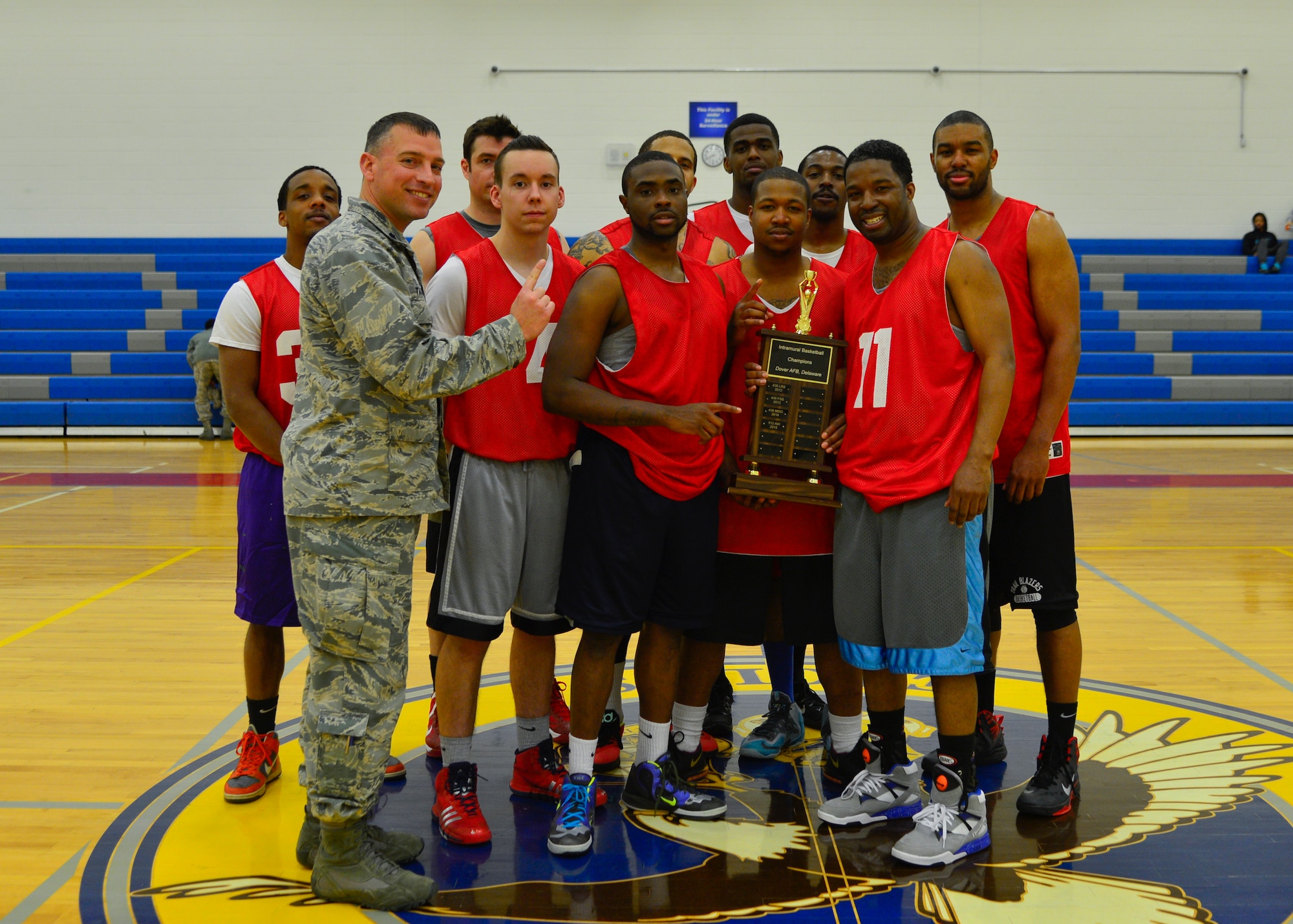 The 512th Airlift Wing intramural basketball team poses for a photo with the championship trophy and Lt. Col. Donald Tasker, 436th Force Support Squadron commander, following their victory against the 436th Aerial Port Squadron for the intramural basketball championship March 18, 2015, at the fitness center on Dover Air Force Base, Del. The 512th AW finished 14-5 overall for the season and won their third championship since becoming a team in 2007. (U.S. Air Force photo/Airman 1st Class William Johnson)