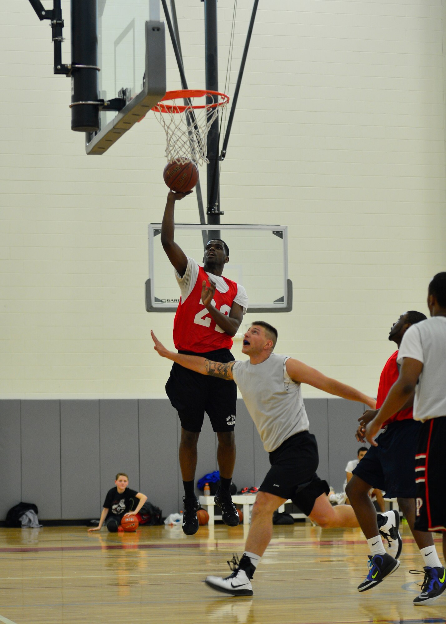 Domonic Townsend, 512th Airlift Wing power forward, finishes a lay-up over Daniel Lauritzen, 436th Aerial Port Squadron player-coach, during the intramural basketball championship game March 18, 2015, at the fitness center on Dover Air Force Base, Del. The 512th AW went 4-1 in the playoffs and won the championship against the 436th APS, 57-45. (U.S. Air Force photo/Airman 1st Class William Johnson)