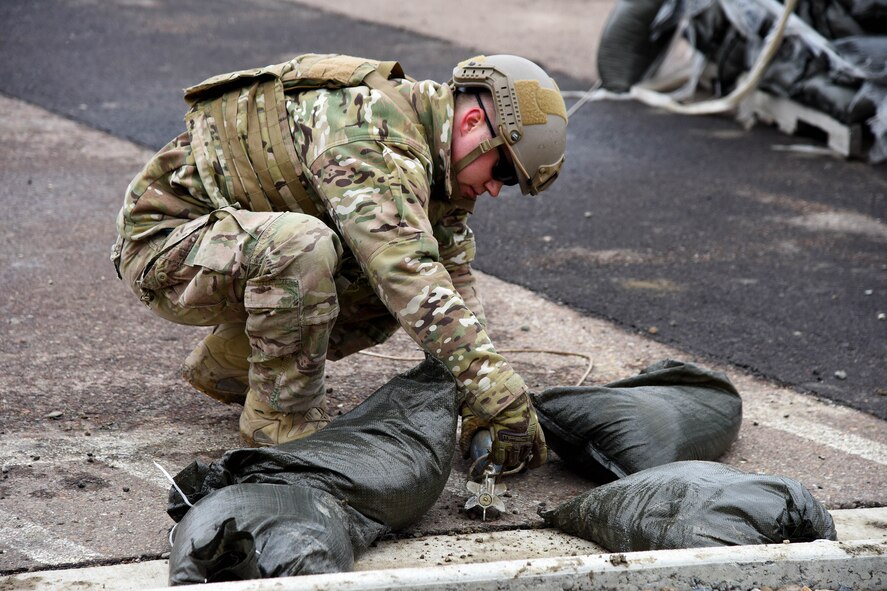 A member of the 341st Civil Engineer Squadron explosive ordnance disposal team removes a rope from a simulated improvised explosive device as part of the Grizzly Rampart training exercise March 17 at Malmstrom Air Force Base. The exercise was implemented to evaluate the readiness of the 341st Missile Wing and ensure first-responder Airmen know and follow the standards set in place for real-world events. (U.S. Air Force photo/Airman 1st Class Collin Schmidt)
