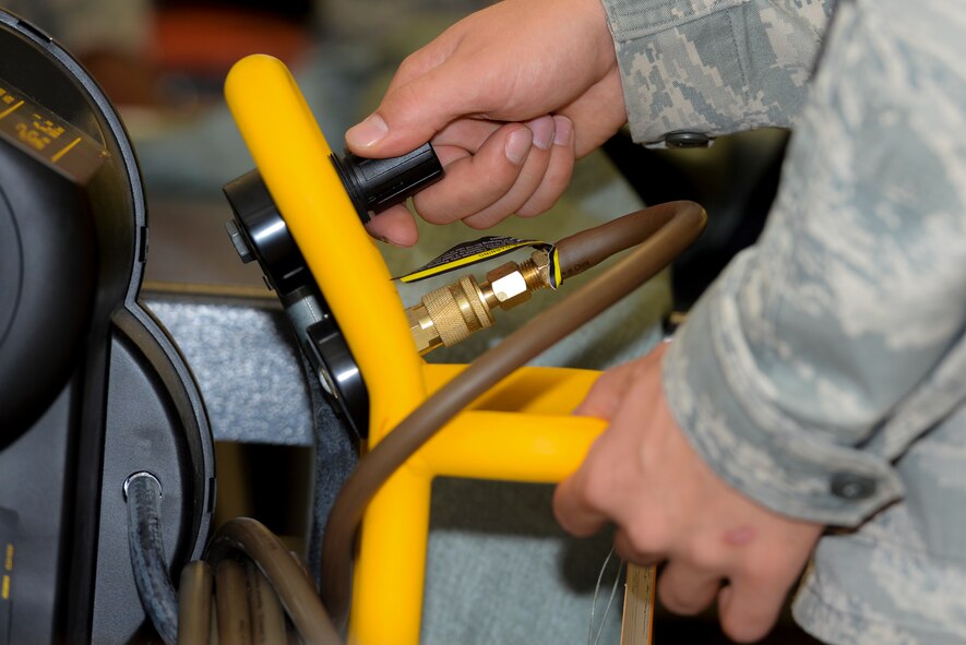 U.S. Air Force Staff Sgt. Kevin Ray, 23d Operations Support Squadron assistant flight line NCO in charge, turns on an air compressor March 19, 2015, at Moody Air Force Base, Ga. Members of the 23d OSS  tested an OTS 600 dry suit for leakage during a pressure drop test inspection. (U.S. Air Force photo by Airman Greg Nash/Released)