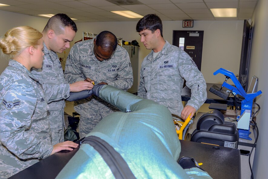 Members of the 23d Operations Support Squadron mark the foot of an OTS 600 dry suit March 19, 2015, at Moody Air Force Base, Ga. Airmen found a leakage hole, marked it and waited to heat seal the hole with adhesive tape before it is tested again. (U.S. Air Force photo by Airman Greg Nash/Released)