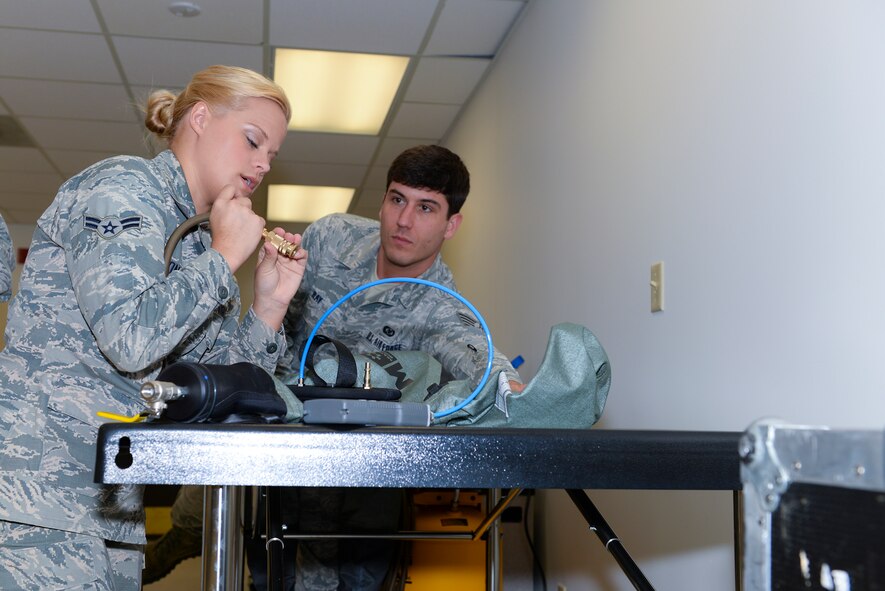 U.S. Air Force Airman 1st Class Jessica Jones, 23d Operations Support Squadron aircrew flight equipment technician, puts an air compressor nozzle on an OTS 600 dry suit March 19, 2015, at Moody Air Force Base, Ga. The air compressor is meant to be placed on the dry suit’s neck stopper to avoid air leakage once the suit is filled with air for a pressure-drop test. (U.S. Air Force photo by Airman Greg Nash/Released)