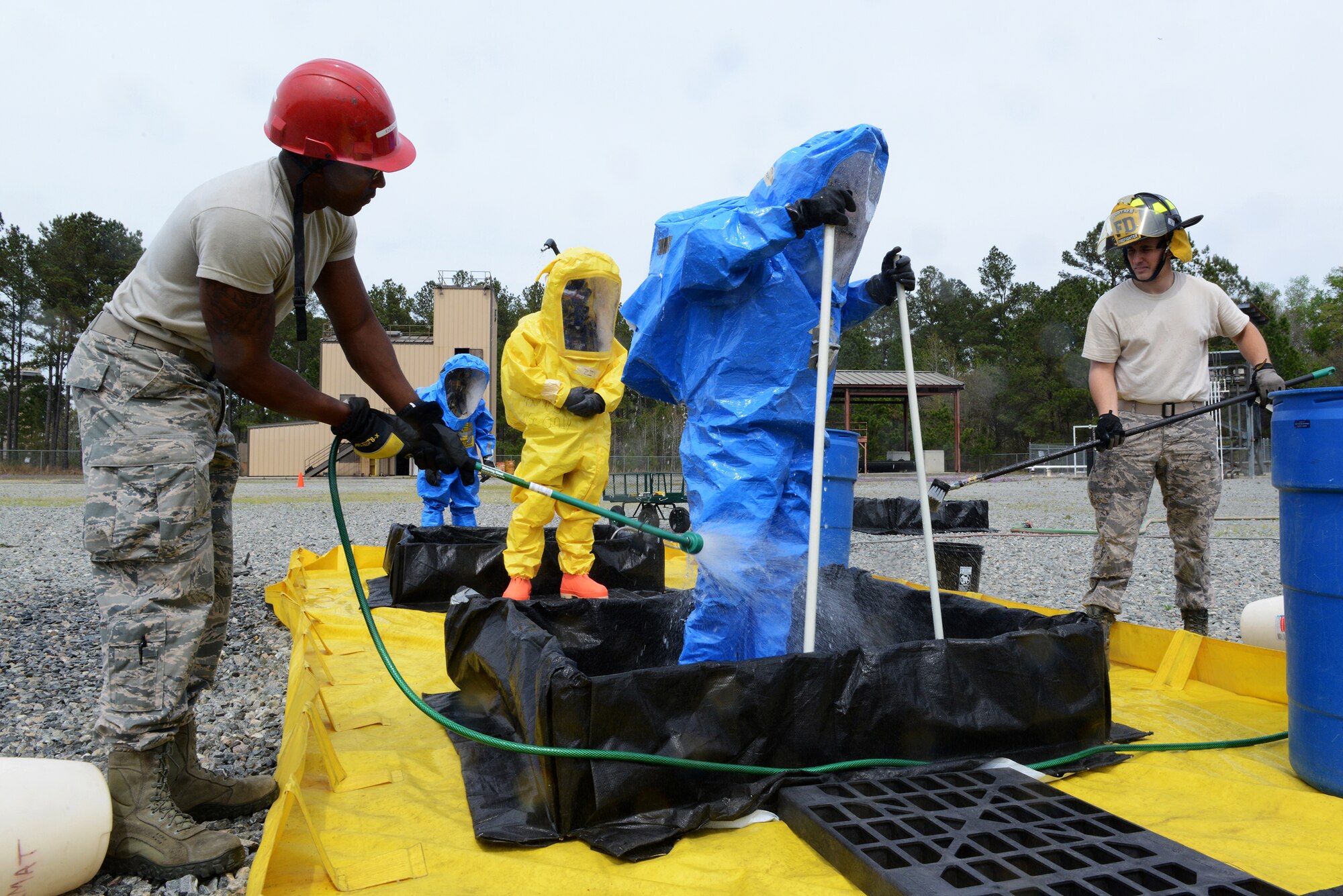 Airmen 1st Class Tyler McFarland, left, and Matthew Montville, 23d Civil Engineer Squadron fire department, sanitize Airmen in hazmat suits during integrated base emergency response capability training March 18, 2015, at Moody Air Force Base, Ga. The Airmen in the hazmat suits completed a scenario before being sanitized. (U.S. Air Force photo by Airman 1st Class Kathleen D. Bryant)