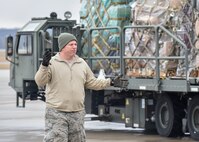 Master Sgt. Timothy Franken, an aerial port rigger with the 76th Aerial Port Squadron here, directs a K-loader cargo transport vehicle up to the rear of a C-5 Super Galaxy cargo aircraft from Dover Air Force Base, Delaware on the flight line here, March 20, 2015. Franken and other Airmen from APS packaged approximately 90 thousand pounds of cargo onto Air Force pallets which were picked up by an aircrew from Dover Air Force Base, Delaware via a C-5 Super Galaxy aircraft. The cargo, which included school supplies, medical items and furniture, was collected by Austintown based Mission of Love charity. U.S. Air Force photo/Eric M. White.