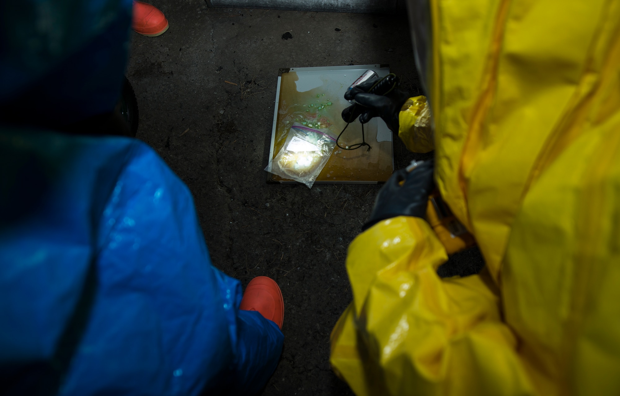 U.S. Air Force Senior Airman Travis Harrelson, right, 23d Civil Engineer Squadron emergency management specialist, and Senior Airman Jeremy Hickson, 23d CES EM specialist, shine a flashlight during the integrated base emergency response capability training March 18, 2015, at Moody Air Force Base, Ga. Harrelson and Hickson used the light during a scenario to assist in identifying the chemical solution that mixed to cause a chemical reaction. (U.S. Air Force photo by Airman 1st Class Ceaira Tinsley/Released)