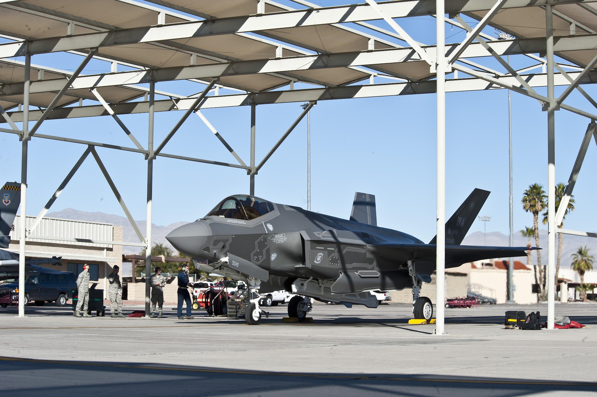 An F-35 sits under a sun shade on the flightline at Nellis Air Force Base, Nev. The Air Force Small Business Innovation Research/Small Business Technology Transfer program office and a small business partner have developed high-temperature, abrasion-resistant coating to improve reliability and maintainability. The F-35 is but one of the weapon systems to benefit from this technology. (Air Force photo by Airman by 1st Class Mikaley Towle) 