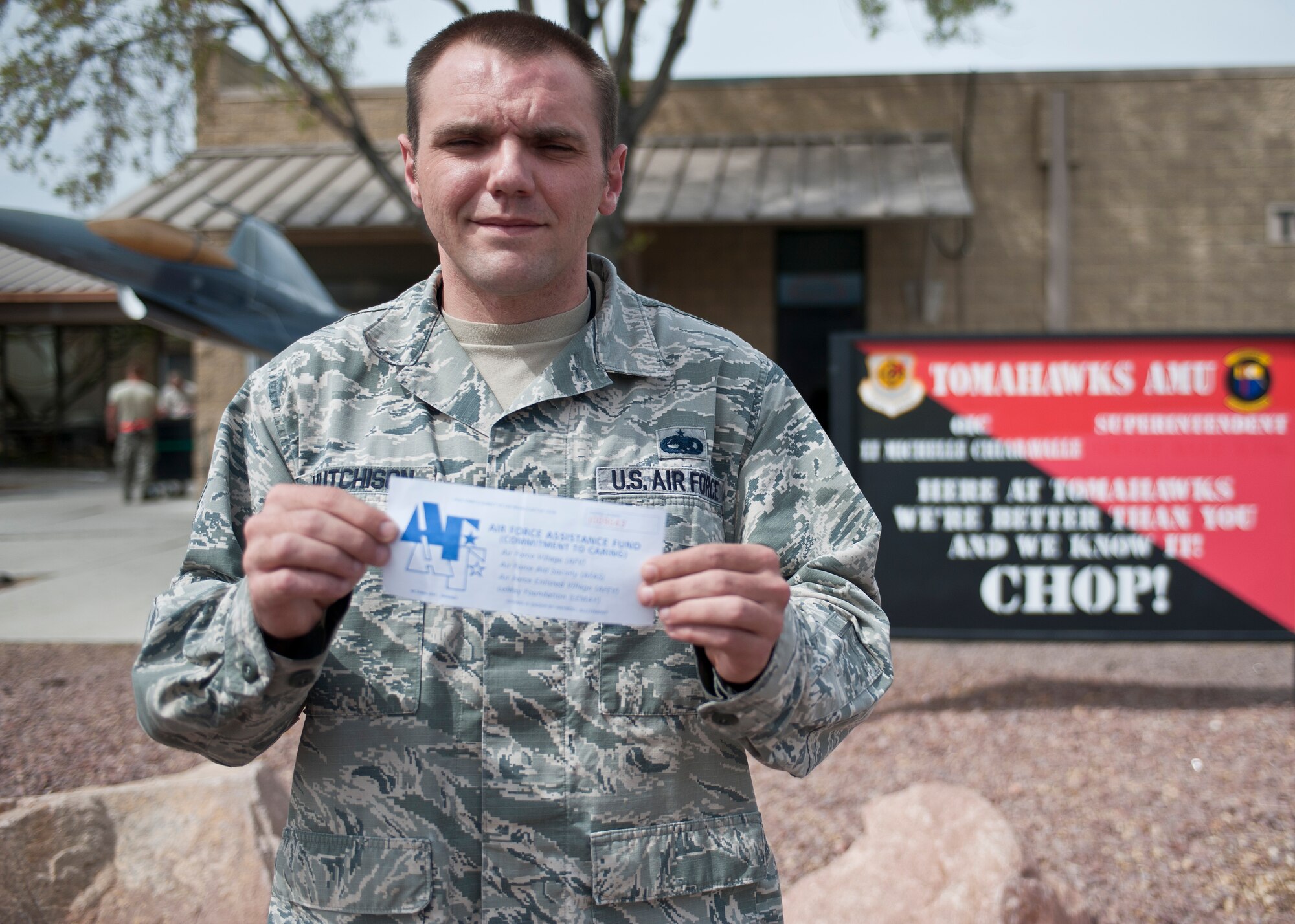 Master Sgt. Dennis Hutchison, 57th Aircraft Maintenance Squadron Tomahawks Aircraft Maintenance Unit production superintendent, poses for a photo with his pledge form for the 2015 Air Force Assistance Fund drive at Nellis Air Force Base, Nev., March 17, 2015. The AFAF drive will run from March 23 until May 1 at Nellis and Creech AFBs, and the Nevada Test and Training Range, and is looking to raise $175,602 for the Air Force Aid Society, the Air Force Enlisted Village, the Air Force Villages Charitable Foundation, and the General and Mrs. Curtis E. LeMay Foundation. (U.S. Air Force photo by Staff Sgt. Siuta B. Ika)