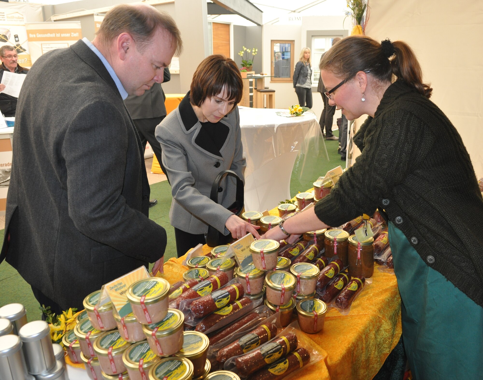 U.S. Air Force Col. Lars Hubert, 52nd Fighter Wing vice commander, and U.S. Air Force Col. Jill Scheckel, 52nd Medical Group commander, examine regional products of the Bitburg area during the opening of this year’s Bitburg Beda market at Bitburg, Germany, March 20, 2015. The Beda Market is a community-wide event where more than 100 local businesses present their products and services at the exhibition tents and elsewhere. (U.S. Air Force photo by Iris Reiff/Released) 