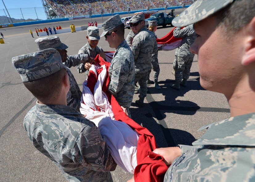 Luke Airmen straighten the American flag prior to the opening ceremony of the race at PIR (U.S. Air Force photo/Senior Airman Devante Williams)