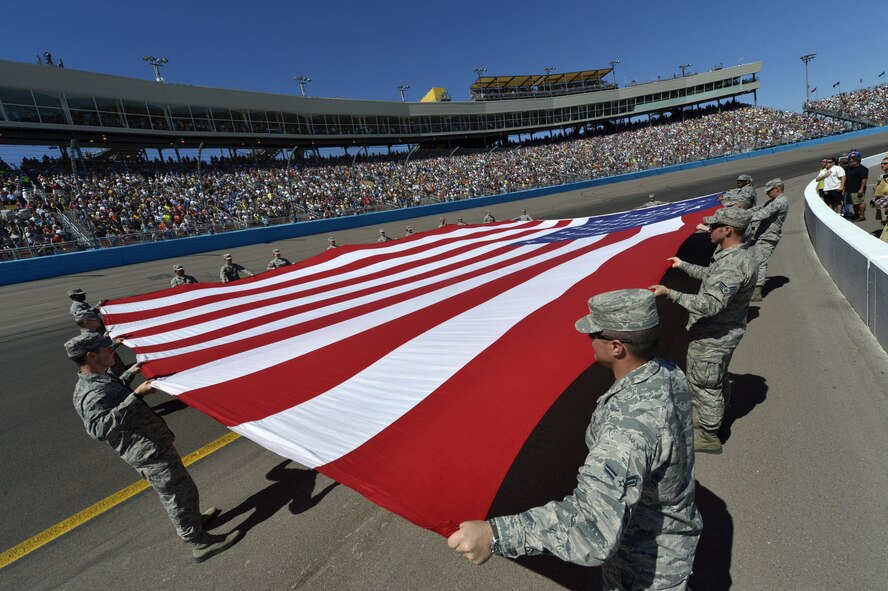 Luke Air Force Base Airmen unfurl the American flag Sunday during the singing of The Star Spangled Banner at the opening ceremony of the CampingWorld.com 500 at the Phoenix International Raceway in Avondale. The flag presentation was featured on national television. (U.S. Air Force photo/Senior Airman Devante Williams)