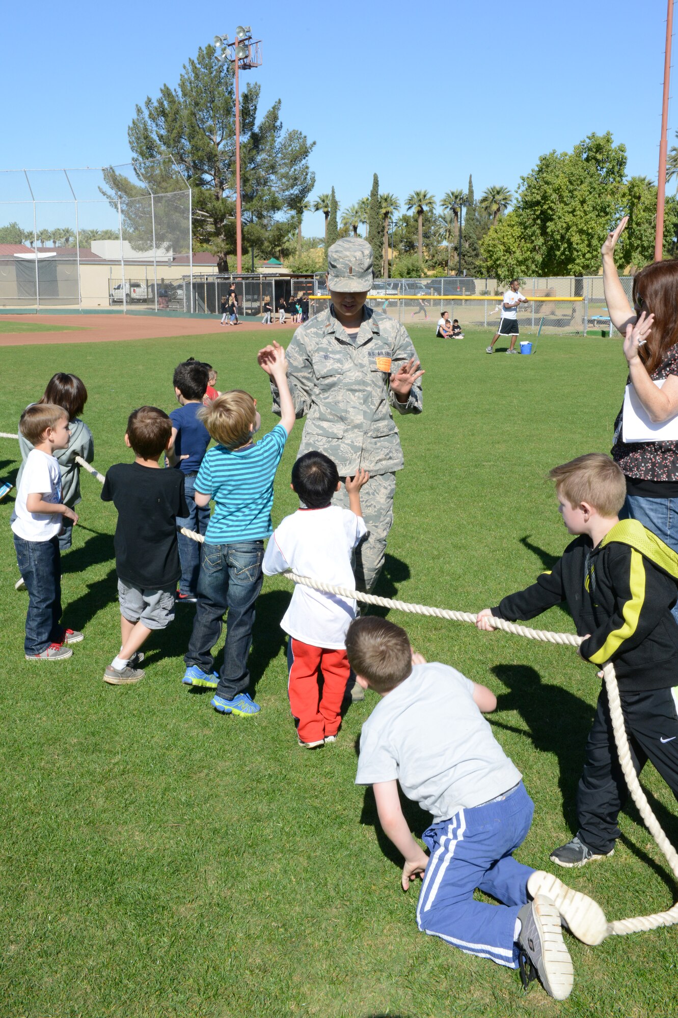 Second Lt. Jennifer Yi, 56th Contracting Squadron contract manager, high-fives children after a tug-o-war match March 6 at Litchfield Elementary School. Airmen supervised game stations during the school’s field day. (U.S. Air Force photo/Senior Airman James Hensley)