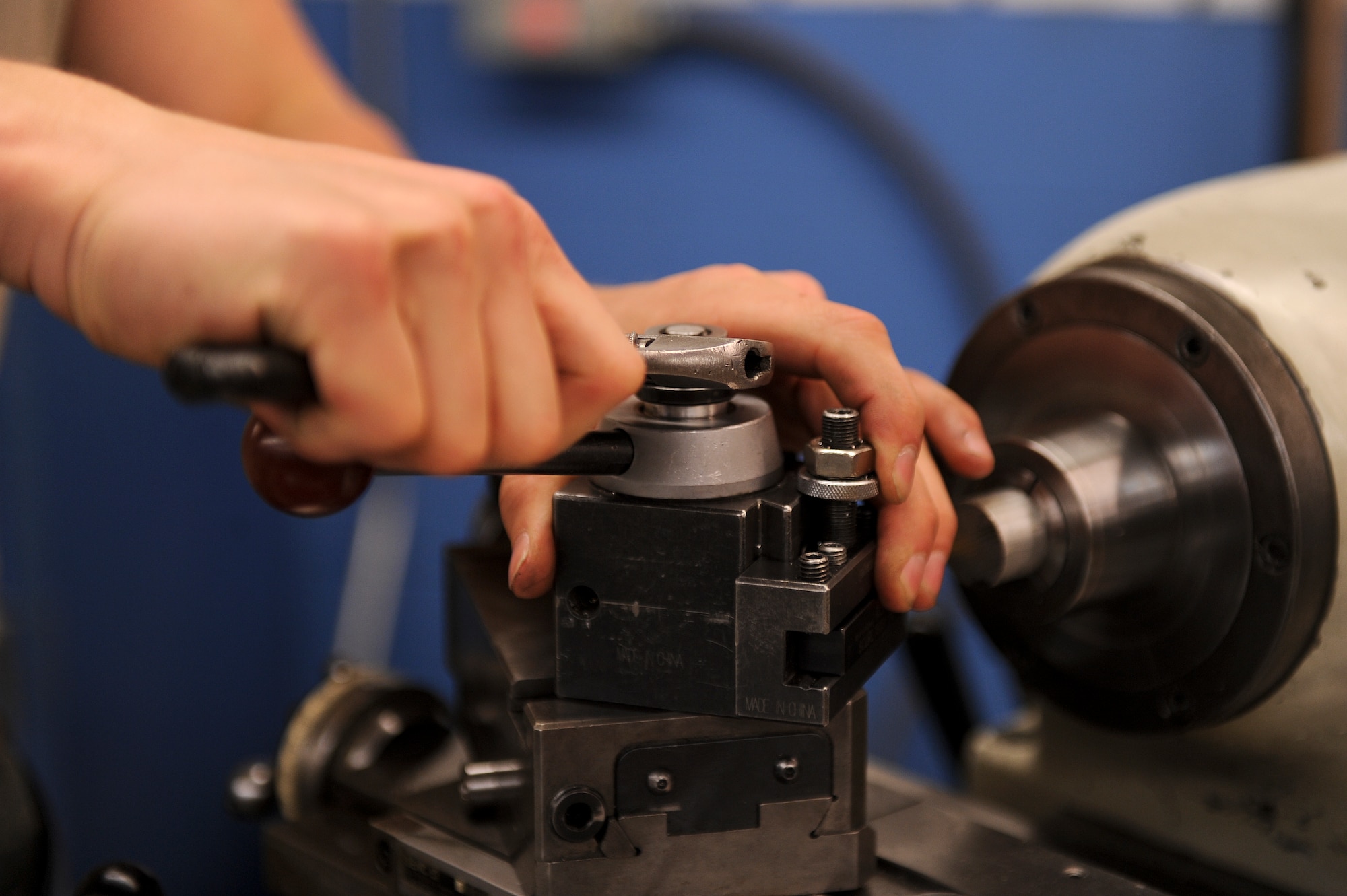 Airman 1st Class Cole Piddington, 4th Equipment Maintenance Squadron aircraft metals technology technician, attaches a cutting tool to a metal lathe March 10, 2015, at Seymour Johnson Air Force Base, North Carolina. A metal lathe is used to create cylindrical items, square a cylinder’s edge or taper a rod with a precise diameter. (U.S. Air Force photo/Airman 1st Class Aaron J. Jenne)