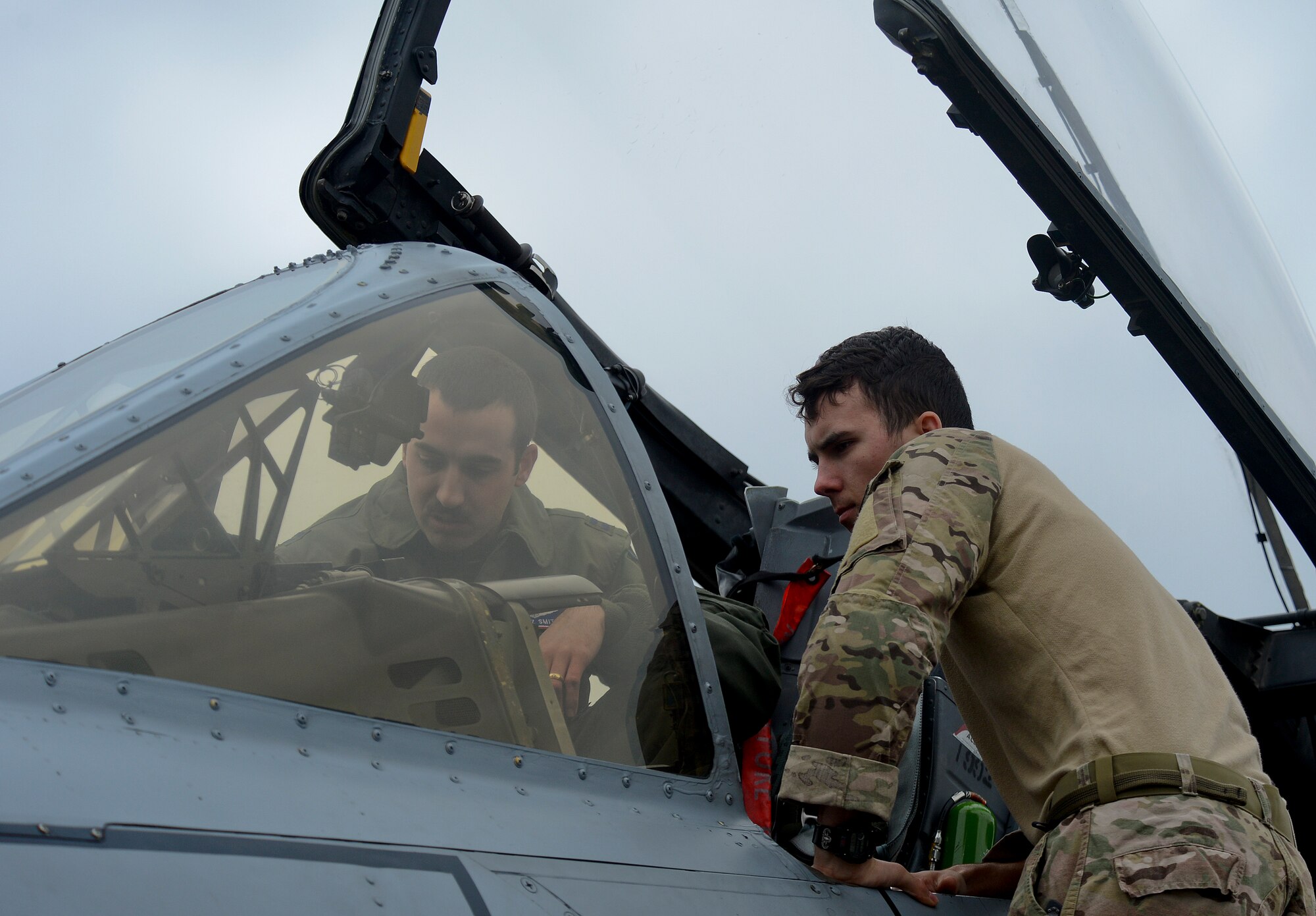 Capt. Eric Smith (left), 354th Expeditionary Fighter Squadron A-10C pilot, talks with Airman 1st Class Devan Trammel, 48th Civil Engineer Squadron Explosive Ordinance Disposal technician, about the features on an A-10C Thunderbolt II on the flightline at Royal Air Force Lakenheath, England, March 19, 2015. The A-10s and 354th EFS Airmen are deployed as part of a Theater Security Package in support of Operation Atlantic Resolve. While at RAF Lakenheath,, the A-10 pilots gave a brief tour of the aircraft to Liberty Wing personnel. (U.S. Air Force photo by Airman 1st Class Trevor T. McBride/Released)