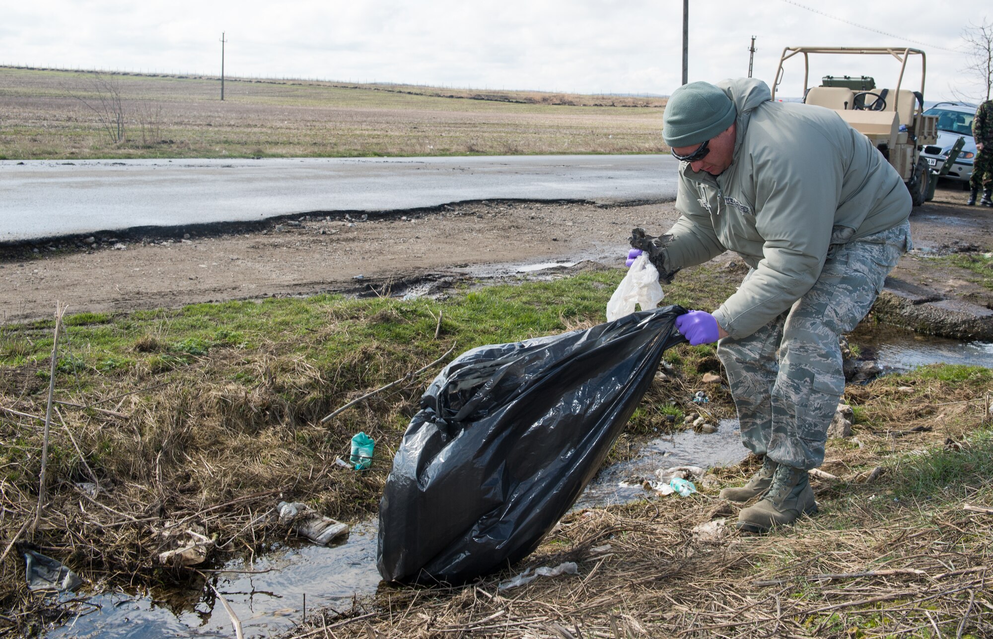 Airmen from the 435th Air Ground Operations Wing and Romania pick up trash at a local water source near Campia Turzii, Romania, during Dacian Warhawk, a two-week training mission designed to increase the interoperability between the U.S. and Romanian allies March 19, 2015. The Airmen took time to give back to the local community in-between training missions. (U.S. Air Force photo/Staff Sgt. Armando A. Schwier-Morales) 