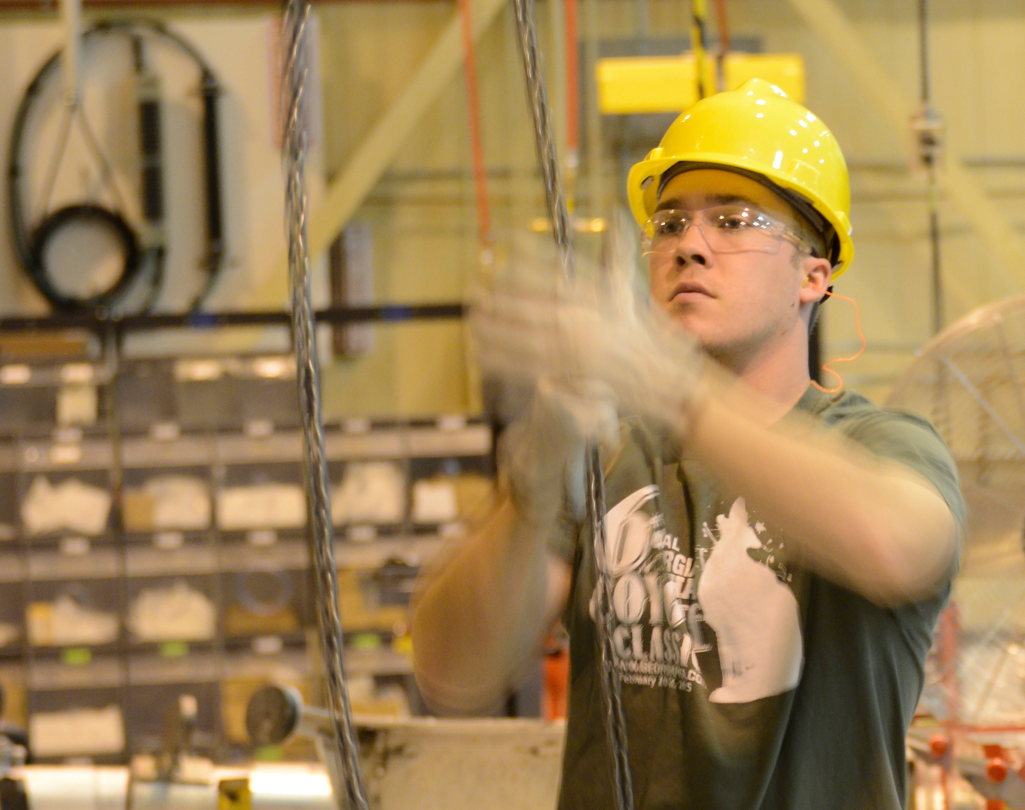 Caleb Lane, 402nd Commodities Maintenance Group sheet metal mechanic helper, uses a chain to help maneuver a wing into a wing fixture. (U.S. Air Force photo by Ed Aspera)