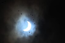 A flock of birds flies in skies above RAF Alconbury, England, at 9:55 a.m., during the final minutes of a solar eclipse, March 20, 2015. Due to cloud coverage, many UK residents were not able to witness the eclipse. (U.S. Air Force photo by Staff Sgt. Jarad A. Denton/Released)