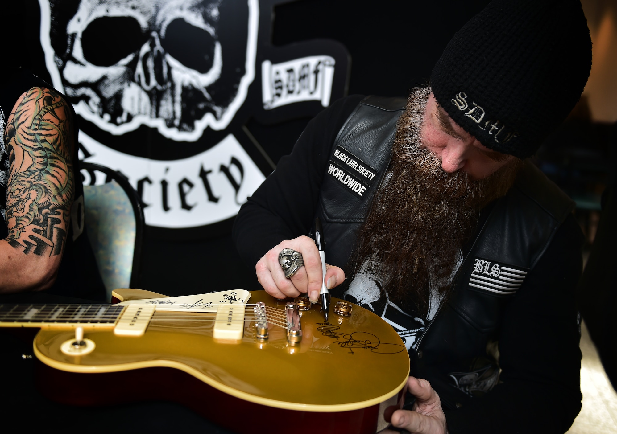 Zakk Wylde, lead vocalist, rhythm guitarist and pianist for the Black Label Society, signs a guitar for an Airman during a meet-and-greet at the Kaiserslautern Military Community Center food court on Ramstein Air Base, Germany, March 17, 2015. Wylde, former guitarist for Ozzy Osbourne, and the band put on a free concert for Team Ramstein with the help of the USO. (U.S. Air Force photos/Staff Sgt. Sara Keller)