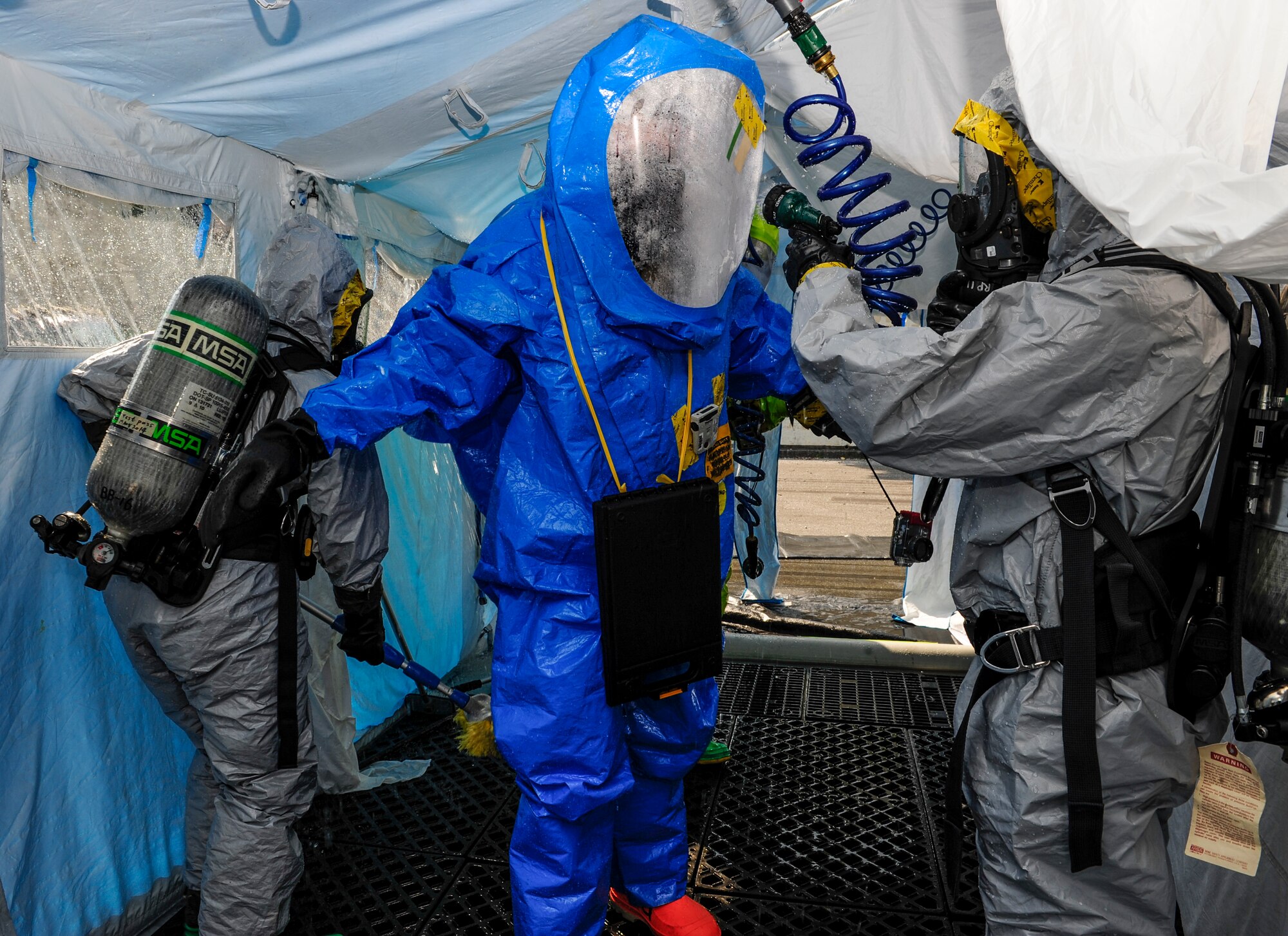 U.S. Air Force Airman 1st Class Joseph Jordan, 18th Civil Engineer Squadron emergency management technician, is sprayed down by a decontamination team during an Integrated Base Emergency Response Capabilities Training exercise March 18, 2015, on Kadena Air Base, Japan. Jordan was cleaned as he left a ‘hot zone,’ a staged hazard environment for anyone without protective gear. (U.S. Air Force photo by Airman 1st Class John Linzmeier)