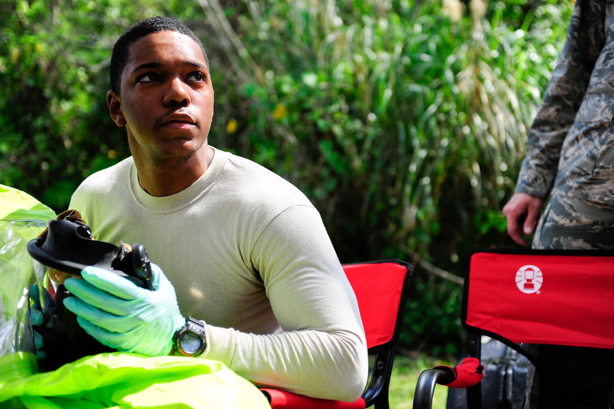 U.S. Air Force Senior Airman Aaron Rogers, 18th Aerospace Medicine Squadron bioenvironmental engineering technician, awaits orders to don personal protective gear in order to respond to a mock emergency during an Integrated Base Emergency Response Capabilities Training exercise March 18, 2015, on Kadena Air Base, Japan. Rodgers is trained to relax and conserve energy before entering a potentially hazardous environment, as his multiple layers of gear can be heavy and coat him in temperatures that are approximately 10 degrees Fahrenheit warmer and can increase the humidity to 100 percent. (U.S. Air Force photo by Airman 1st Class John Linzmeier)