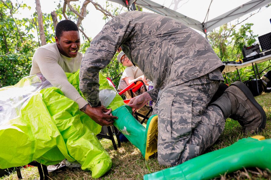 U.S. Air Force Senior Airman Aaron Rogers, 18th Aerospace Medicine Squadron bioenvironmental engineering technician, begins to put on a Level-A suit with the help of his wingman during an Integrated Base Emergency Response Capabilities Training exercise March 18, 2015, on Kadena Air Base, Japan. Level-A suits are the highest level of protective gear a responder can use to protect against from hazardous chemicals and radiation. (U.S. Air Force photo by Airman 1st Class John Linzmeier)