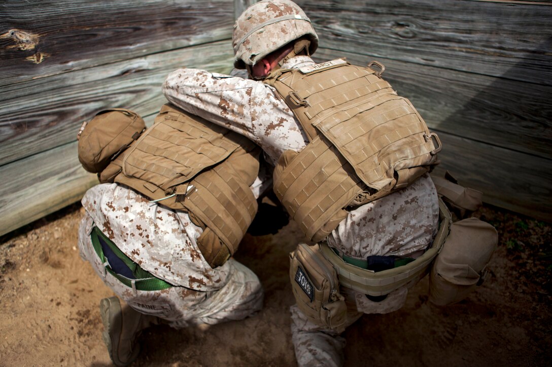 Marine Lance Cpl. Nathaniel Paine, left, covers up after tossing a practice grenade during an exercise with Headquarters Battery, 2nd Battalion, 10th Marine Regiment on Fort Bragg, N.C., March 10, 2015. Paine is assigned to 2nd Transportation Support Battalion, Combat Logistics Regiment 2, 2nd Marine Logistics Group.